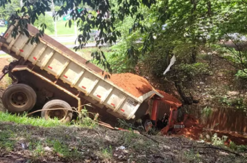Caminhão desgovernado atinge carro, poste e cai em córrego 