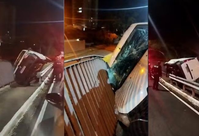 Motorista perde controle e furgão fica pendurado em grade de viaduto